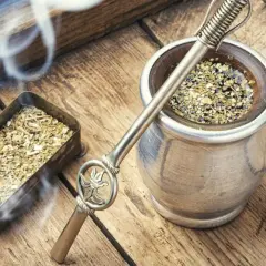 Gorąca yerba mate, parująca z metalowego naczynia, obok pojemnika z suszem. Czas na odkrycie jej wyjątkowego smaku.
