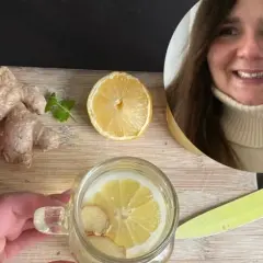 Kobieta przygotowuje orzeźwiającą herbatę z imbirem i cytryną. Na desce leżą świeże korzenie imbiru i plaster cytryny.
