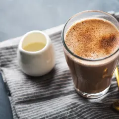 Aromatic bawarka co to? Pyszna kawa z mlekiem i cynamonem, obok dzbanuszek z mlekiem i złota łyżeczka.