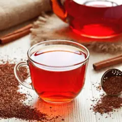 Aromatyczny rooibos zielony i czerwony w filiżance i dzbanku, z cynamonem i anyżem.
