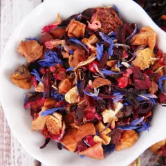 Mieszanka suszone owoce do herbaty: kawałki jabłek, hibiskus, płatki róży i chabru tworzą barwny bukiet.