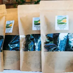 Kilka opakowań z gruzińską herbatą Plantacia. W przezroczystym okienku widać ciemne liście.