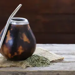 Naczynie do yerba mate, matero palo santo, gotowe do pierwszego użycia. Obok garść suszu i metalowa bombilla.