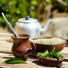 Tradycyjny kubek z yerba mate, obok miseczka z suszem i świeża mięta. Idealny zestaw na orzeźwiający napój.