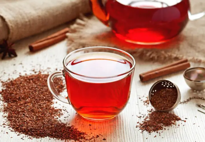Aromatyczny rooibos zielony i czerwony w filiżance i dzbanku, z cynamonem i anyżem.