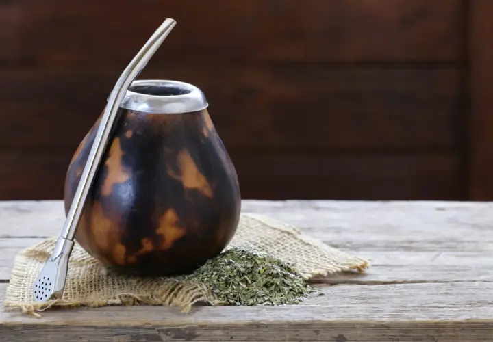 Naczynie do yerba mate, matero palo santo, gotowe do pierwszego użycia. Obok garść suszu i metalowa bombilla.