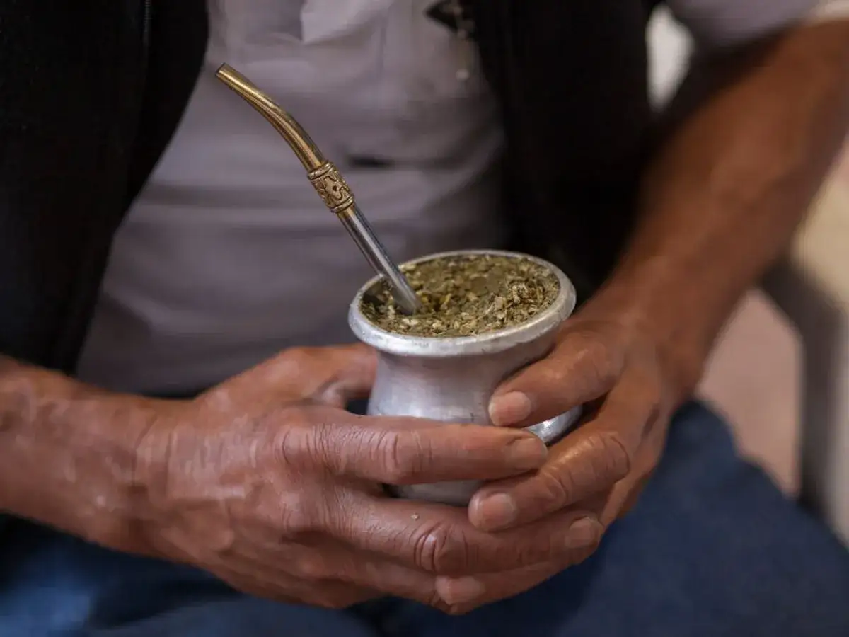 Mężczyzna trzyma naczynie z yerba mate. Nap&oacute;j ten ma bardzo mało kcal, co czyni go zdrowym wyborem.